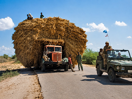 SOMALIA 1993: UN MEZZO MILITARE AR/76 AFFIANCA UN CAMION LOCALE STRACARICO DI PAGLIA LUNGO LE STRADE DI BALAD.