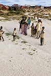 UN GRUPPO DI BAMBINI E CIVILI SOMALI OSSERVA IL PASSAGGIO DEL CONTINGENTE ITALIANO DA UN'ALTURA SABBIOSA.