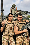 DUE PARACADUTISTI ITALIANI DELLA 10ª COMPAGNIA “DRAGHI” POSANO ARMATI DAVANTI A UN MEZZO BLINDATO VCC-1 CAMILLINO DURANTE LA MISSIONE IBIS IN SOMALIA.