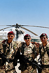 TRE PARACADUTISTI ITALIANI DELLA 10ª COMPAGNIA “DRAGHI” POSANO ARMATI SULLA PISTA DELL'AEROPORTO DI MOGADISCIO, DAVANTI A UN ELICOTTERO MIL MI-8 DELLE NAZIONI UNITE.