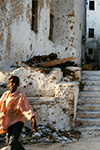 BAMBINI GIOCANO SULLE SCALE DI EDIFICI GRAVEMENTE DANNEGGIATI E CRIVELLATI DI COLPI A MOGADISCIO IN SOMALIA NEL 1993.