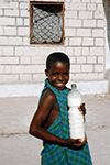 UNA BAMBINA SOMALA SORRIDE TENENDO IN MANO UNA GRANDE BOTTIGLIA DI PLASTICA PIENA DI LATTE A MOGADISCIO NEL 1993.